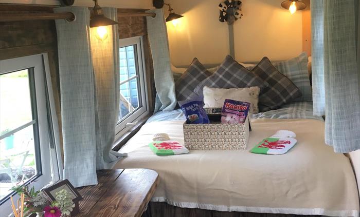 Interior Shepherds Hut all cosy & ready! A welcome hamper awaits. Relax into the memory foam mattress with welsh blankets, hot water bottles & the mos